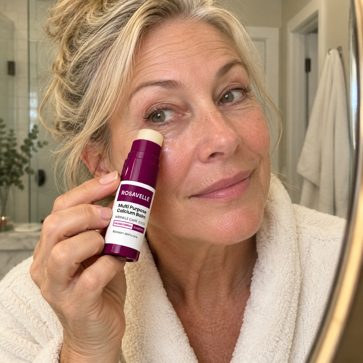 Woman applying Rosavelle balm under her eye